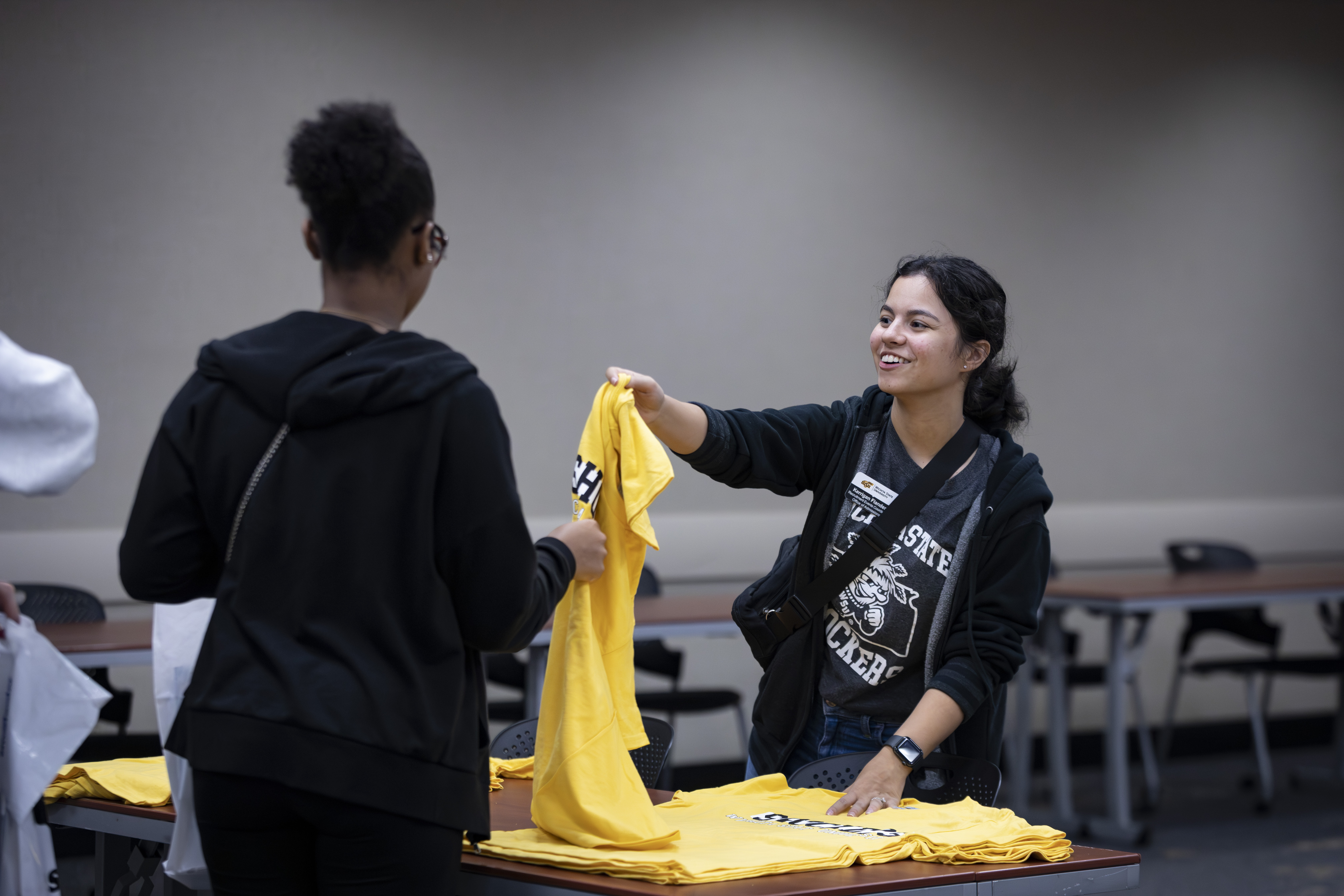 Student receiving a tshirt at black and yellow day
