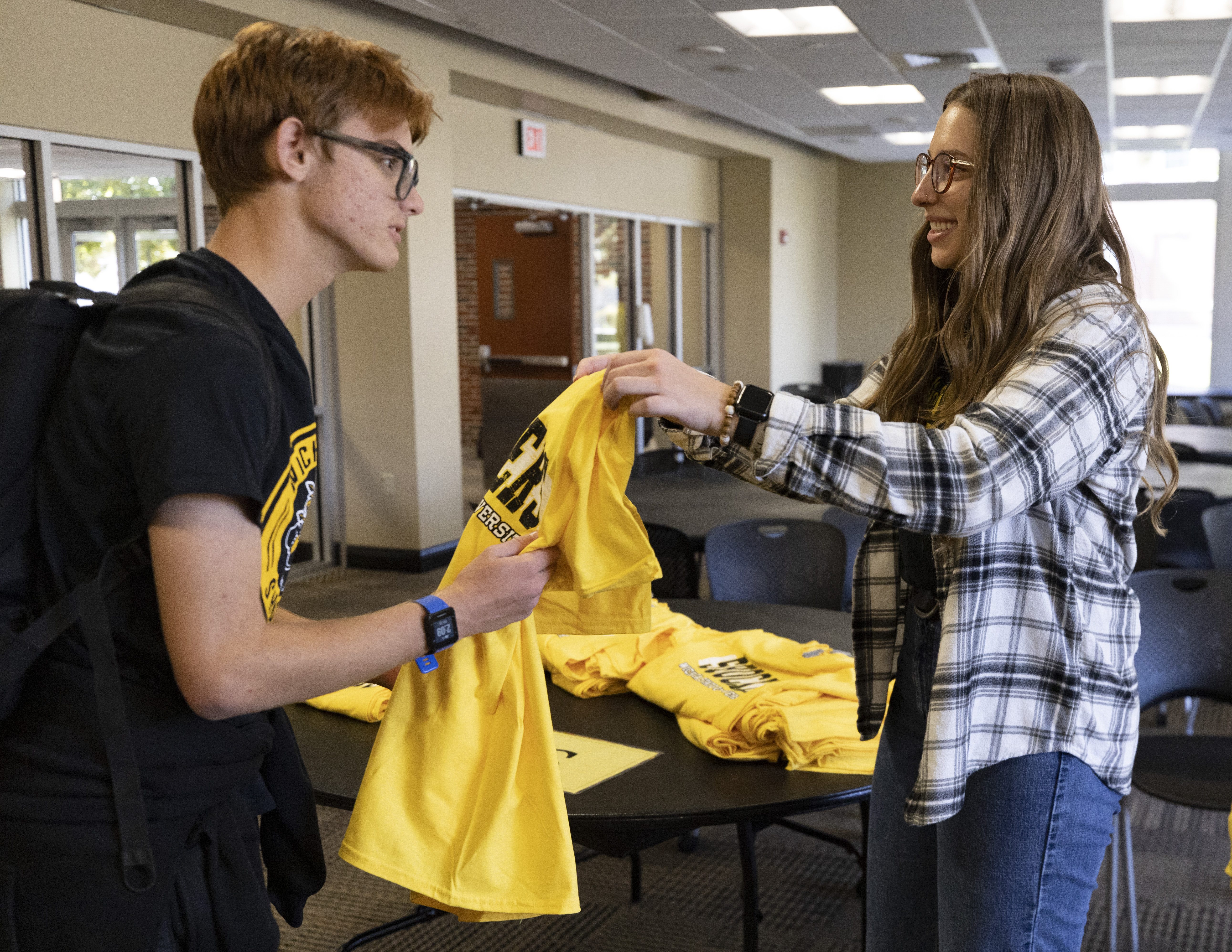 Student receiving a tshirt at black and yellow day